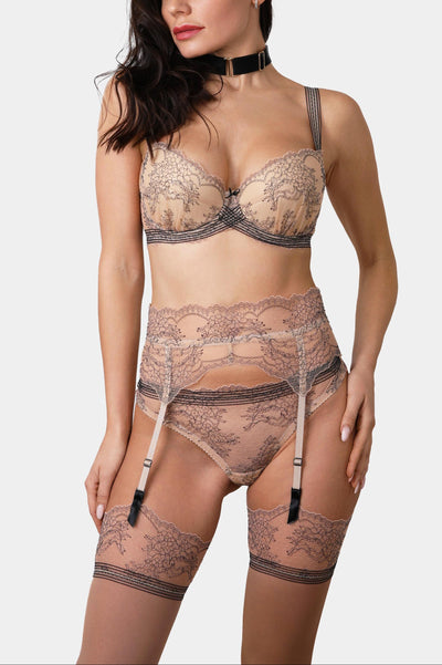 Model wearing the V.I.P.A Tattoo Nude lace suspender belt in nude with lace-top stockings and the lace push-up bra